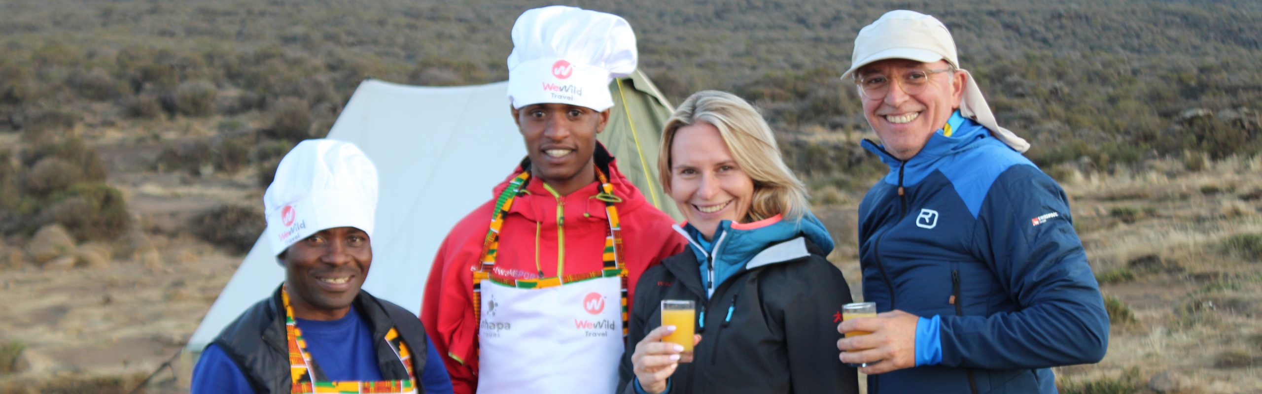 Visitor enjoying fresh juice while relaxing at camp and admiring beautiful Lemosho Route scenery.