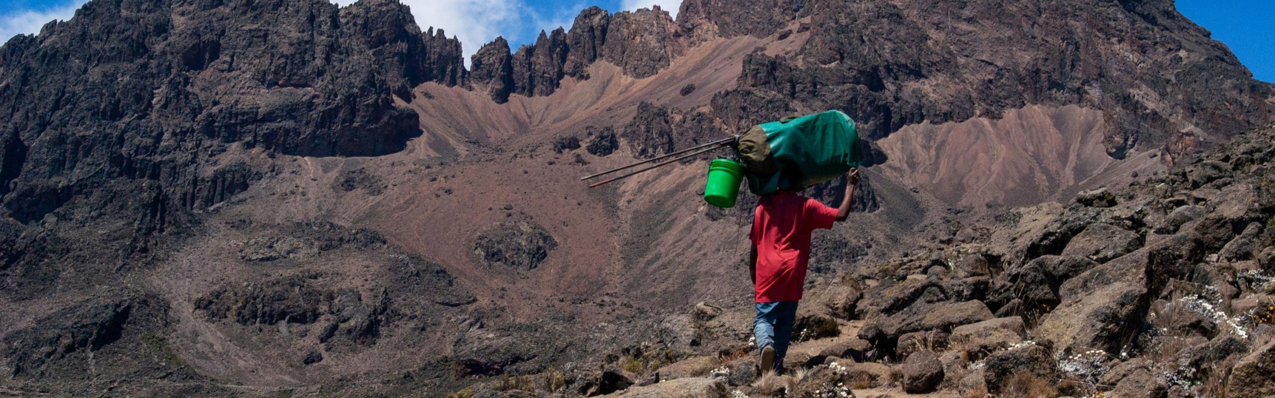 Porter carrying trekking supplies along the 5-day Marangu Route on Kilimanjaro