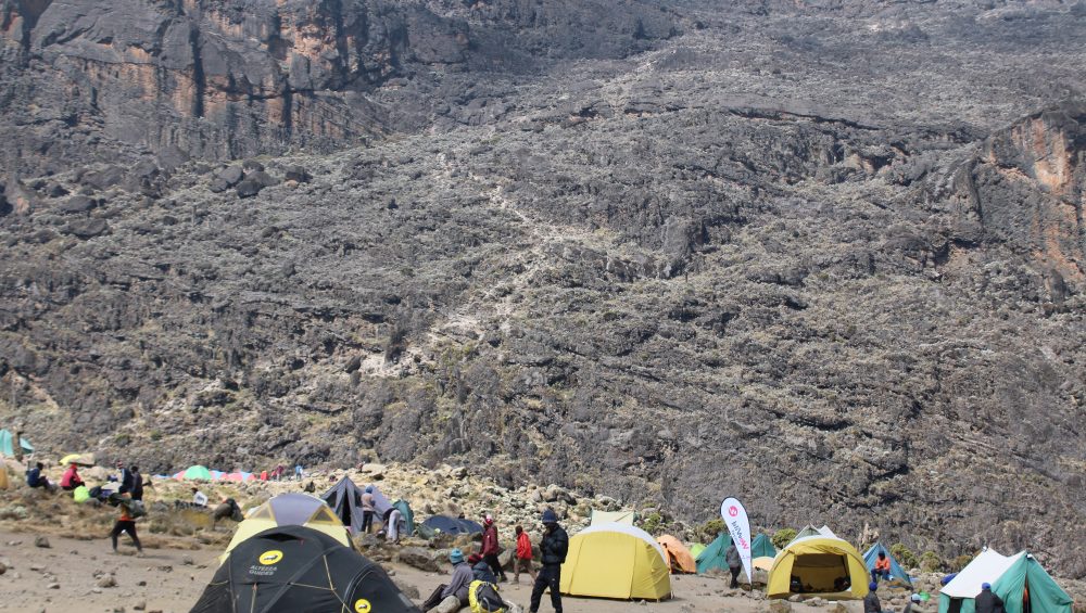 Hikers trekking a scenic Kilimanjaro route through mountain landscapes toward the summit in Tanzania