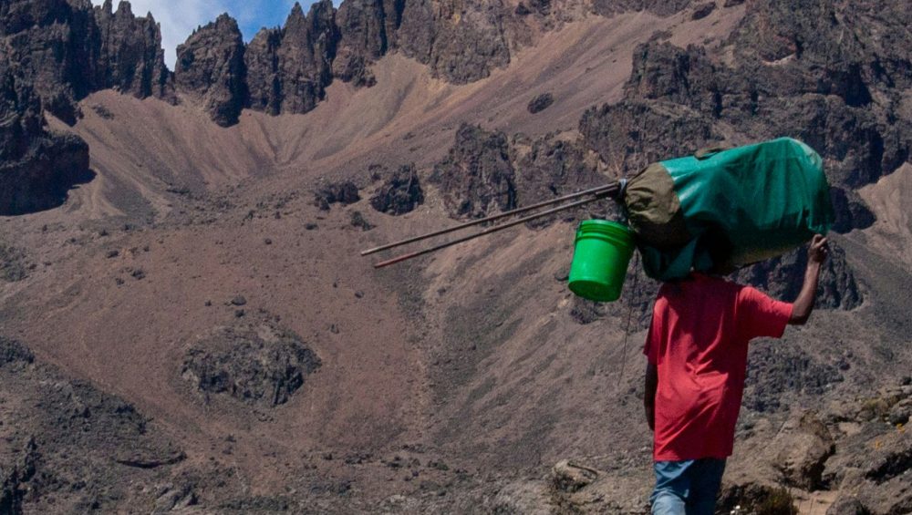 Trekkers climbing Mount Kilimanjaro through scenic mountain route