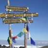Climbers trekking Mount Kilimanjaro while learning official park fees, permits, camping, and rescue costs for 2026.