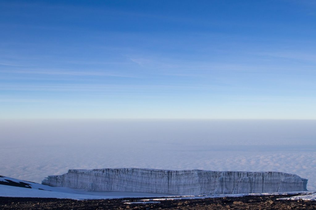 Snow-covered peak of Mount Kilimanjaro with clear sky and glacial ice formation visible.