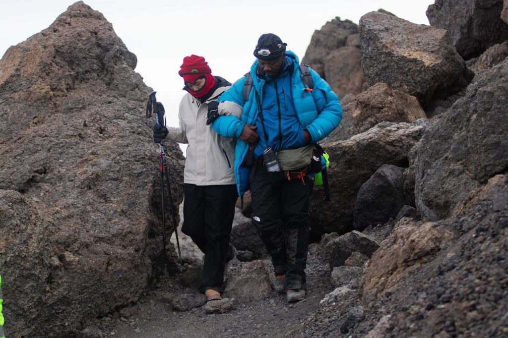 Experienced Kilimanjaro guide helping climbers stay safe during a high-altitude trek on Mount Kilimanjaro