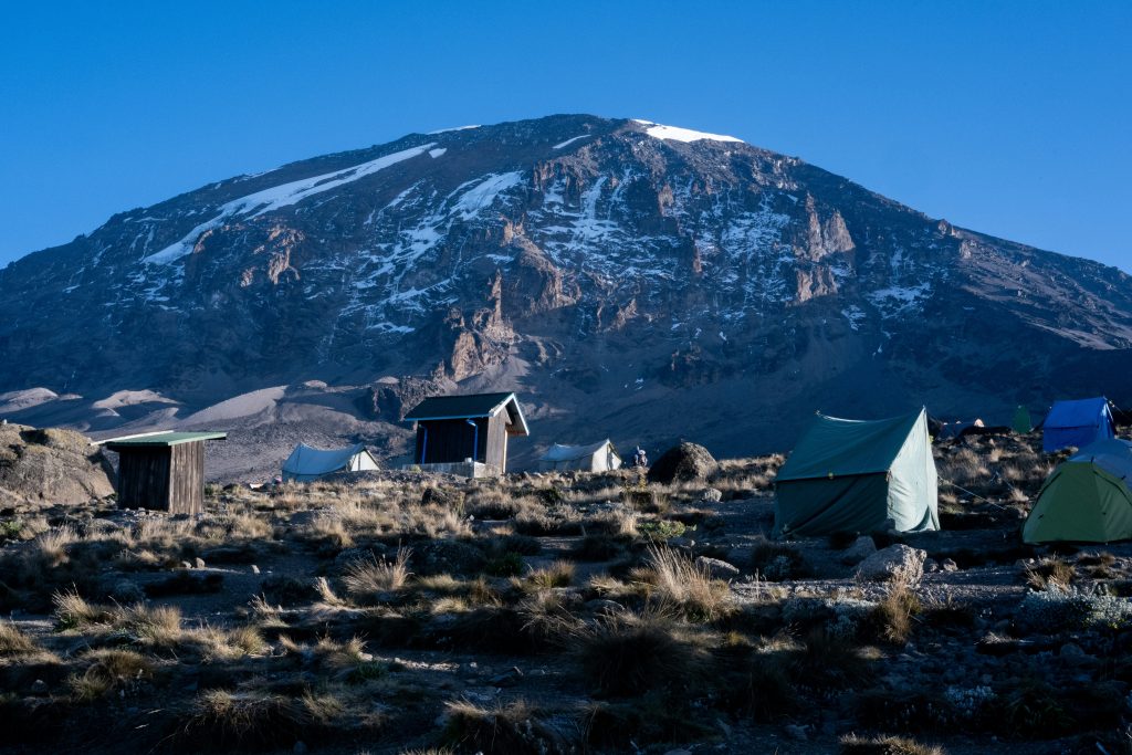 Mount Kilimanjaro under clear skies with snow visible near the summit region.