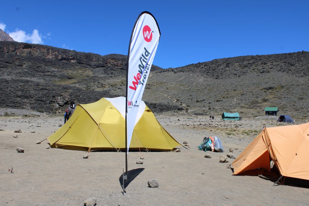 Mountain Kilimanjaro camp with tents surrounded by high-altitude landscapes during a trekking adventure.
