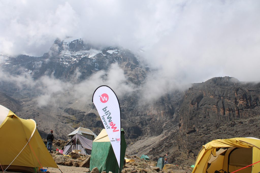 Campsite tent on Mount Kilimanjaro surrounded by high-altitude mountain scenery during a trekking adventure.