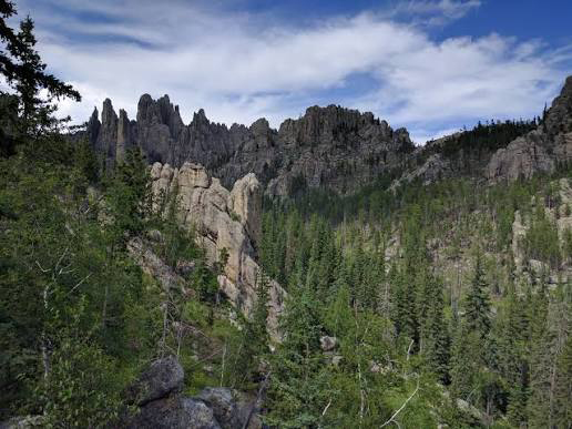 Black Hills in South Dakota and Wyoming, USA featuring forested ancient mountains with rounded peaks and exposed rocky formations.