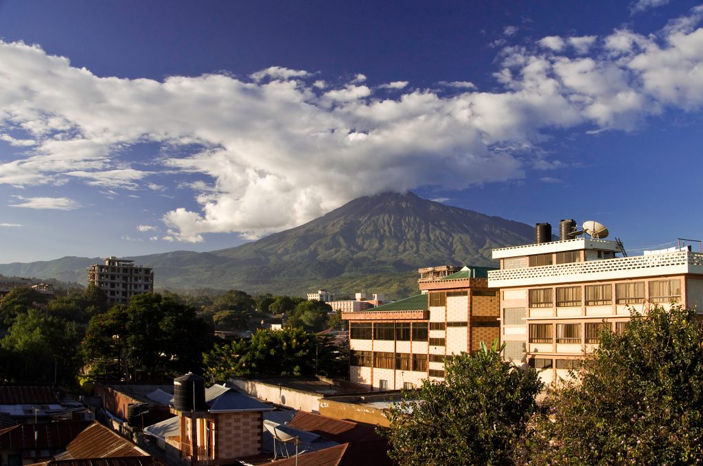 Traveler looking at Mount Meru scenery near Arusha before climbing Mount Kilimanjaro.