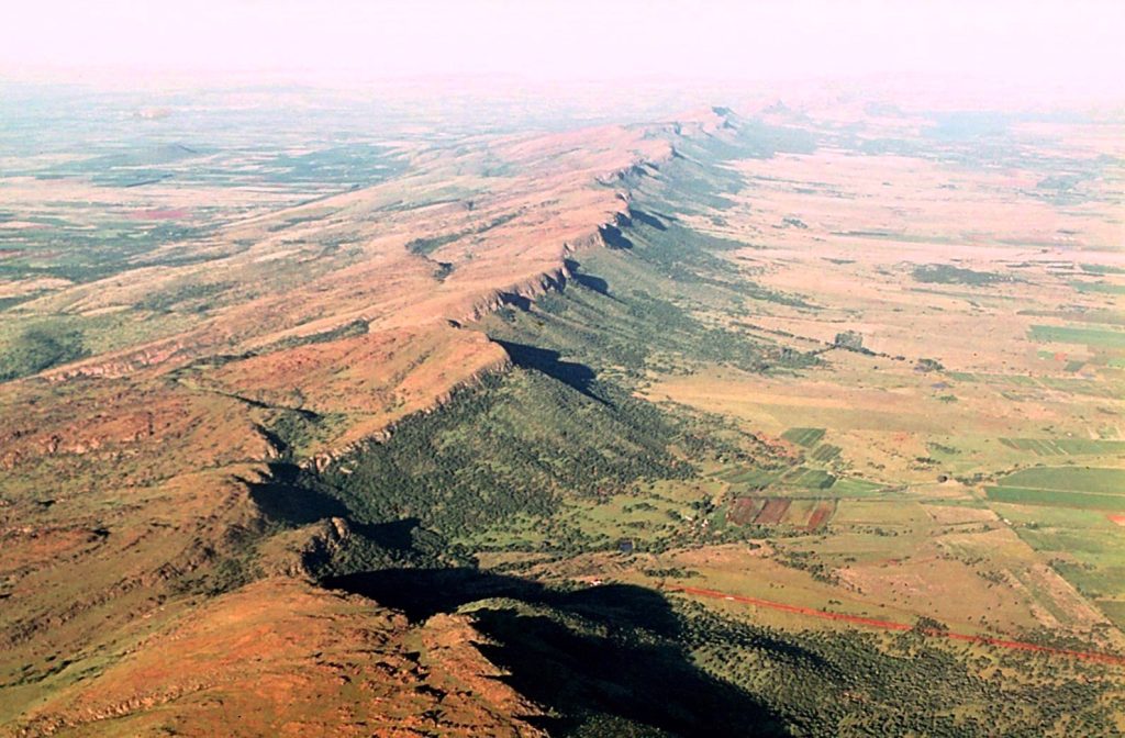 Magaliesberg Mountains in South Africa showing ancient low mountain ridges, rocky slopes, and green valleys shaped by billions of years of erosion.