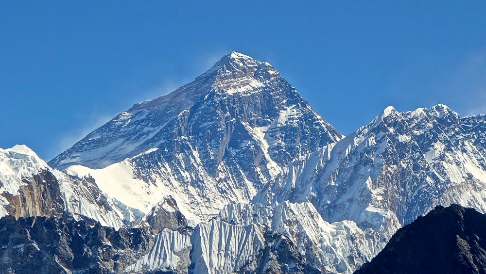 Mount Everest snow-covered peak rising above clouds in the Himalayas Nepal and China border
