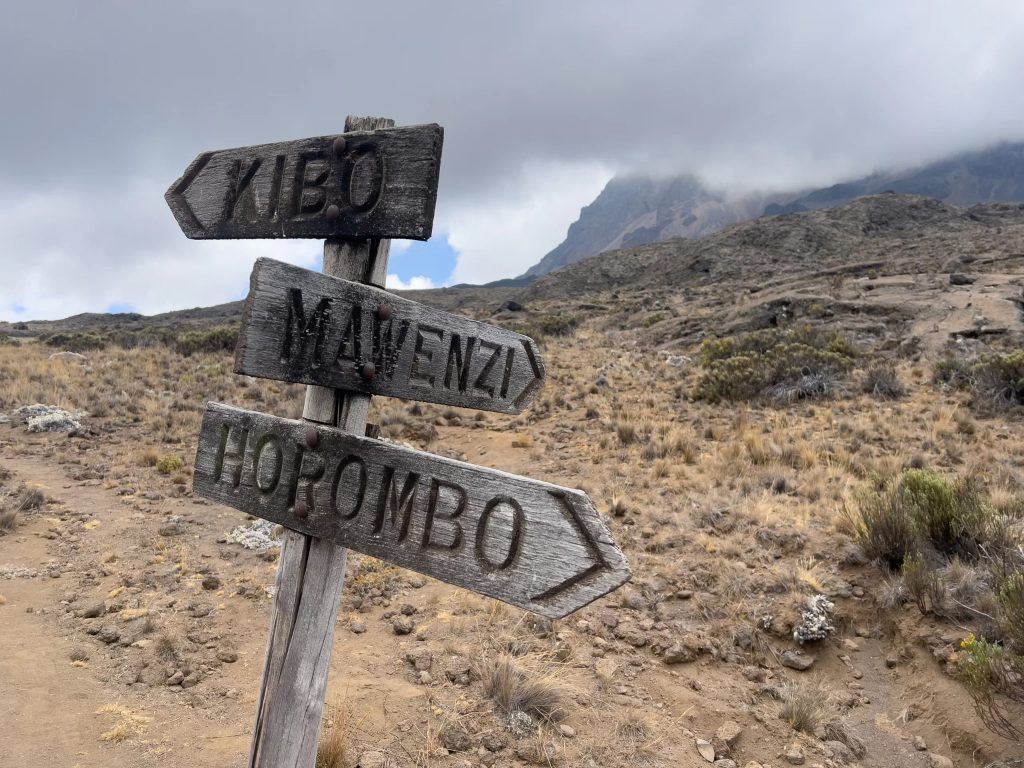 Signboard showing directions to Mawenzi, Kibo Hut, and Horombo on Mount Kilimanjaro trails.