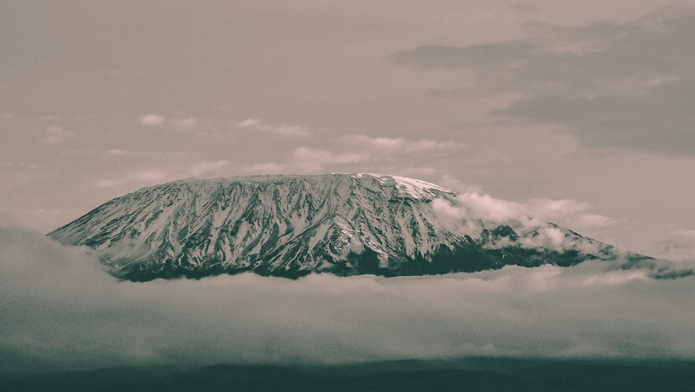 Hikers climbing the 8-Day Lemosho Route on Kilimanjaro through scenic landscapes toward Uhuru Peak summit.