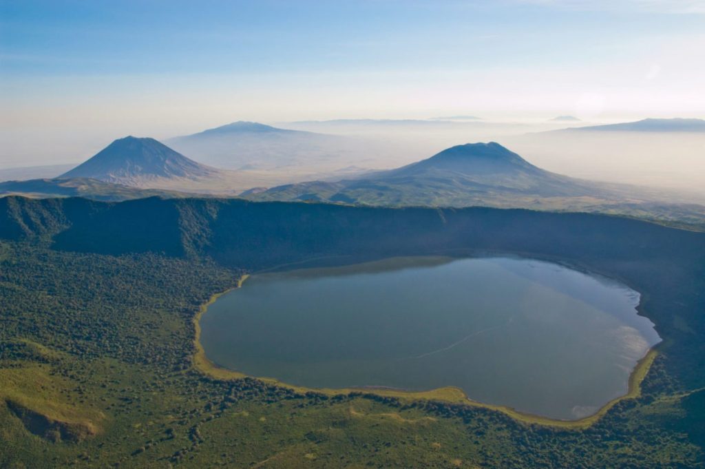 Ngorongoro Highlands with volcanic landscapes, green rolling hills, Maasai villages, and sweeping views of the Great Rift Valley.