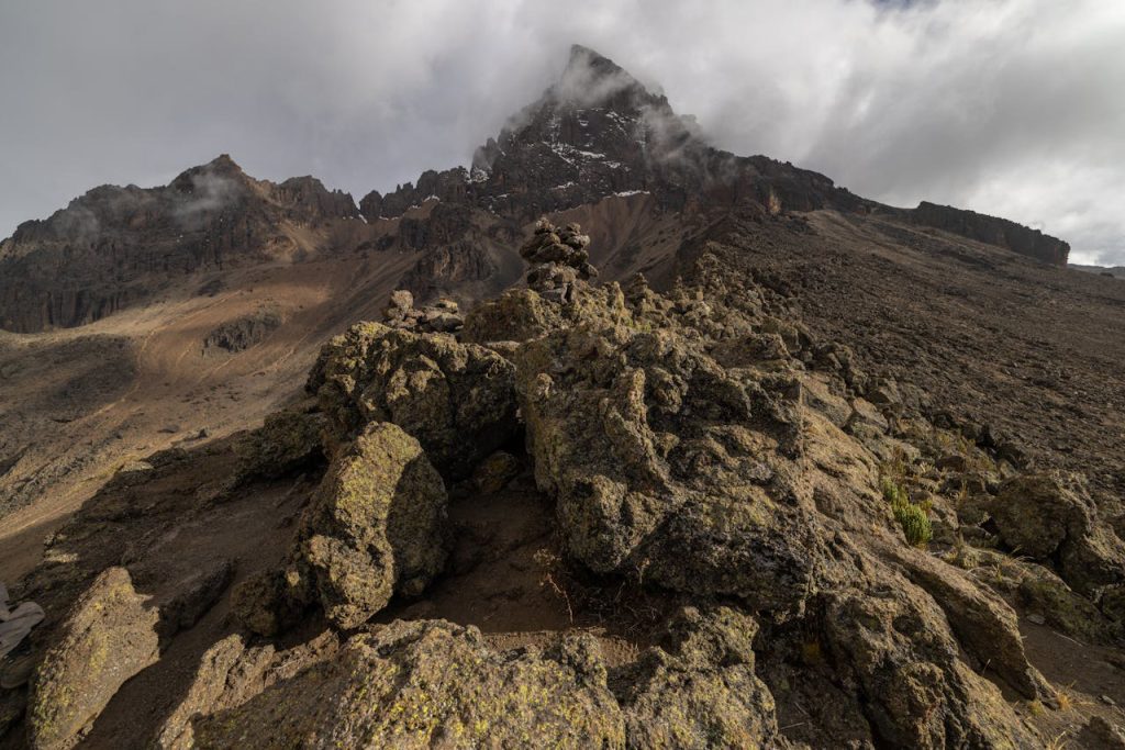 Hikers ascending the Umbwe Route on Mount Kilimanjaro through dense rainforest and steep mountain terrain.