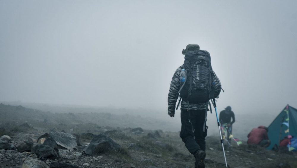 Budget climbers trekking Mount Kilimanjaro with local guides during an affordable and well-organized mountain expedition.