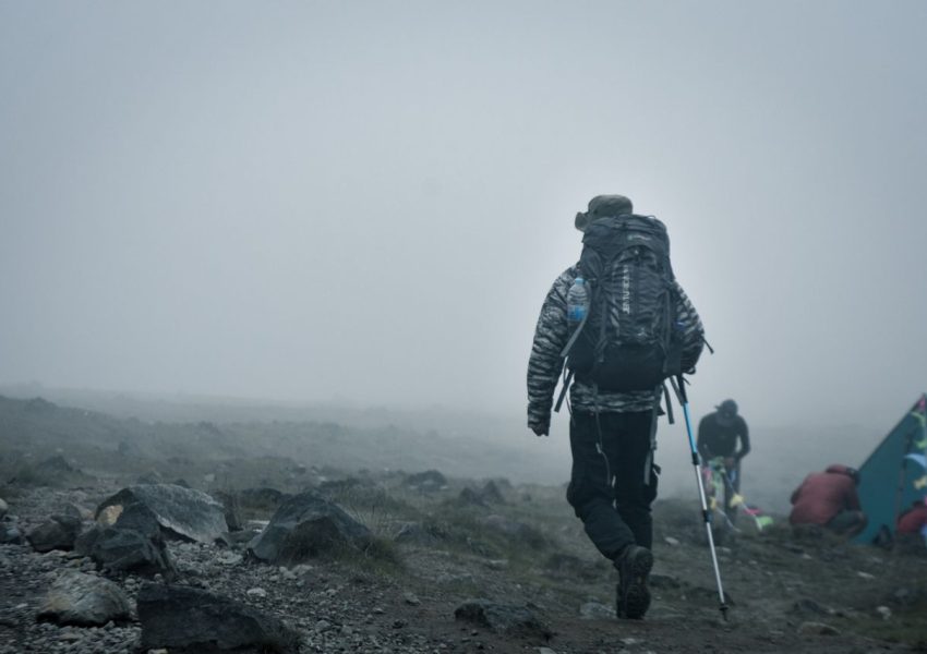 Budget climbers trekking Mount Kilimanjaro with local guides during an affordable and well-organized mountain expedition.