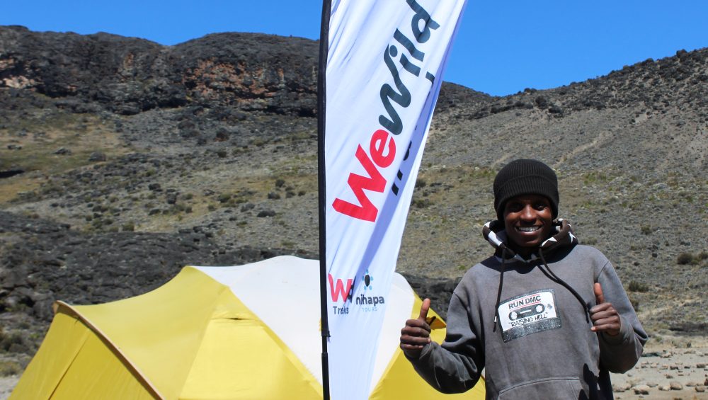 Hikers walking along the scenic Rongai Route toward the summit of Mount Kilimanjaro
