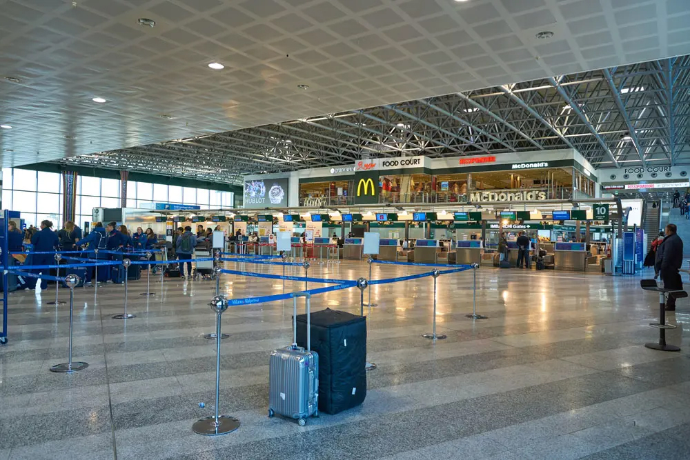 Milan Malpensa Airport terminal where travelers begin direct flights from Italy to Tanzania adventures
