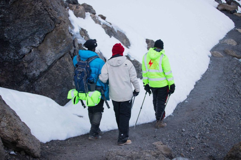 Step-by-step Kilimanjaro climbing journey showing trekkers preparing, hiking, and reaching the mountain summit.