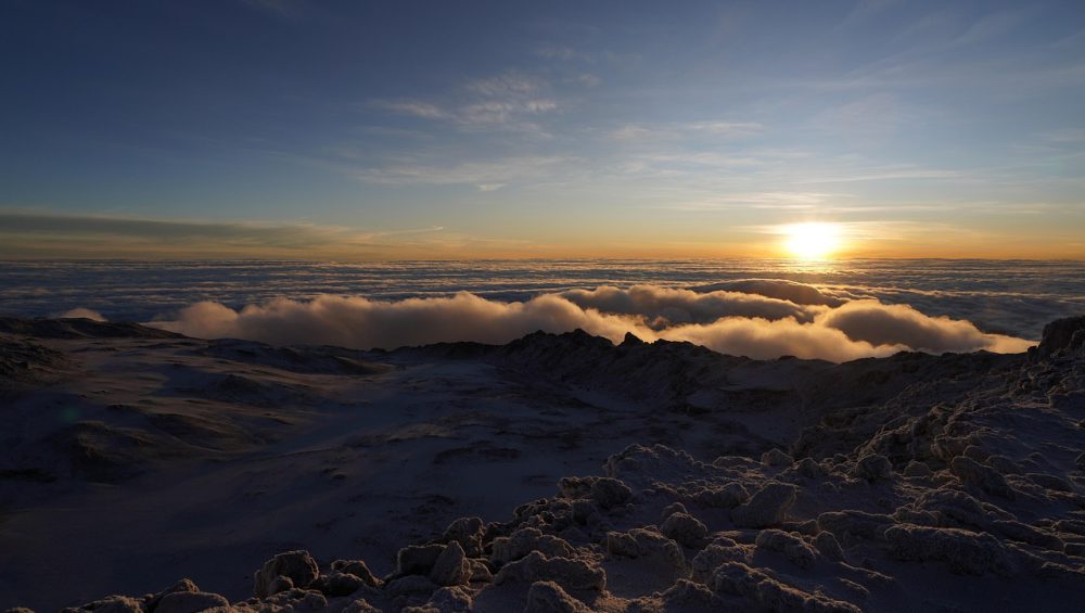 Kilimanjaro summit night climbers hiking under stars toward Uhuru Peak before sunrise on Mount Kilimanjaro